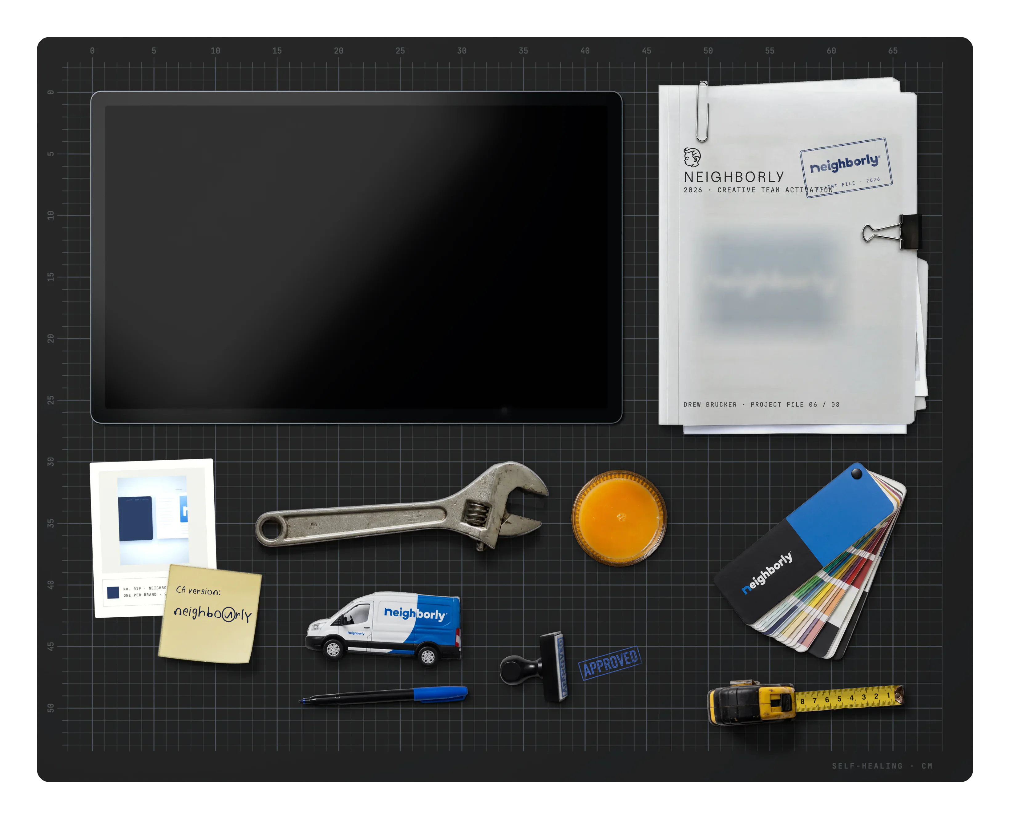 Neighborly on the desk: the project file, archive cards, a sticky note, a pipe wrench, a toy Neighborly van, a marker, a glass of orange juice, an APPROVED rubber stamp, a Neighborly fan deck and a tape measure